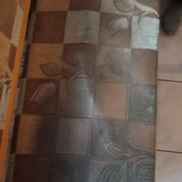 Shinycar24h - Szczegółowe ujęcie wzorzystego siedziska krzesła z motywem kwiatowym i kratką, ukazujące potencjalne zabrudzenia i potrzebę odświeżenia tapicerki.