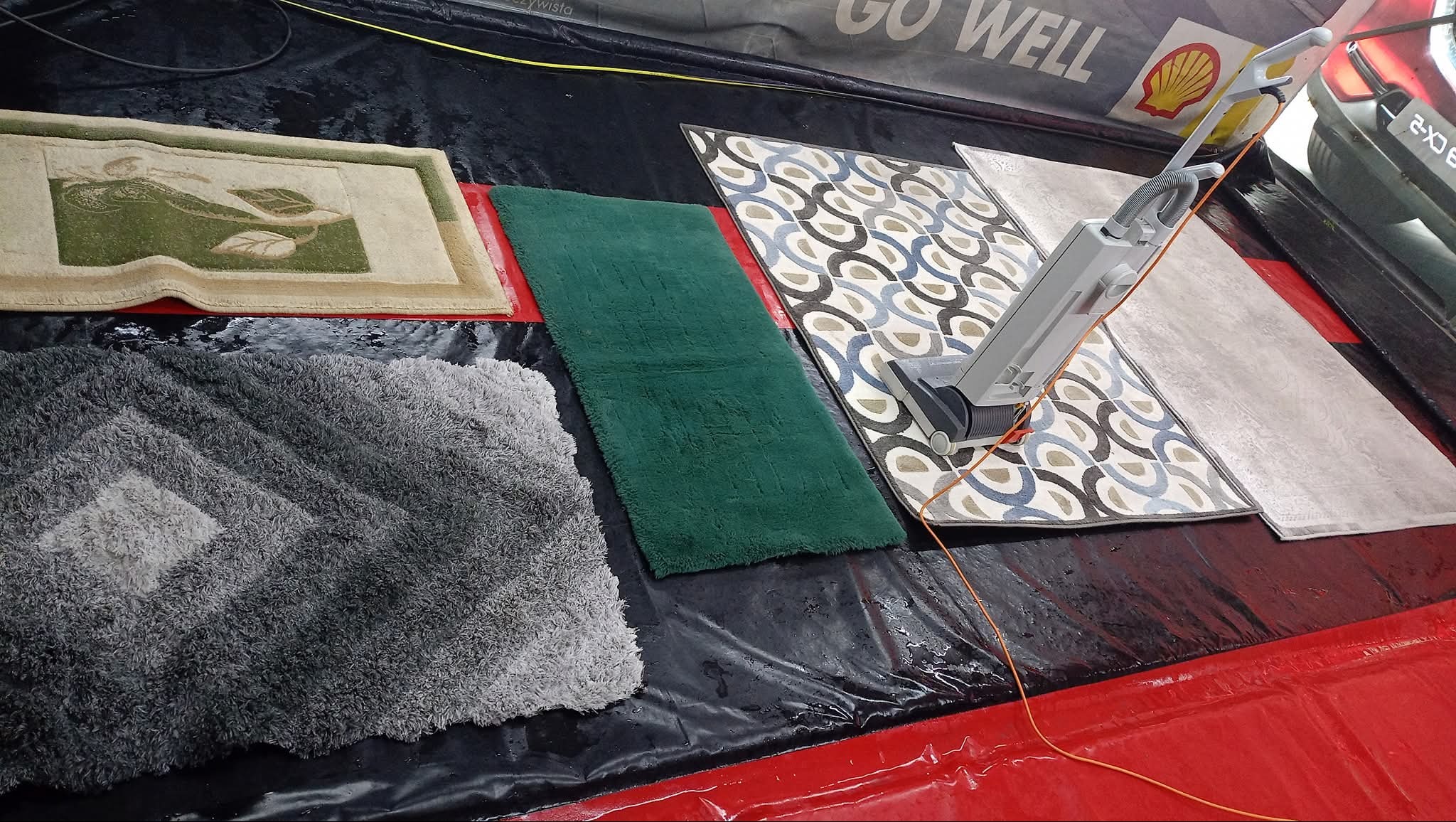 Profesjonalne czyszczenie dywanów: Różne wzory i kolory dywanów poddawane procesowi prania z użyciem specjalistycznego sprzętu. Widoczne detale i struktura włókien.