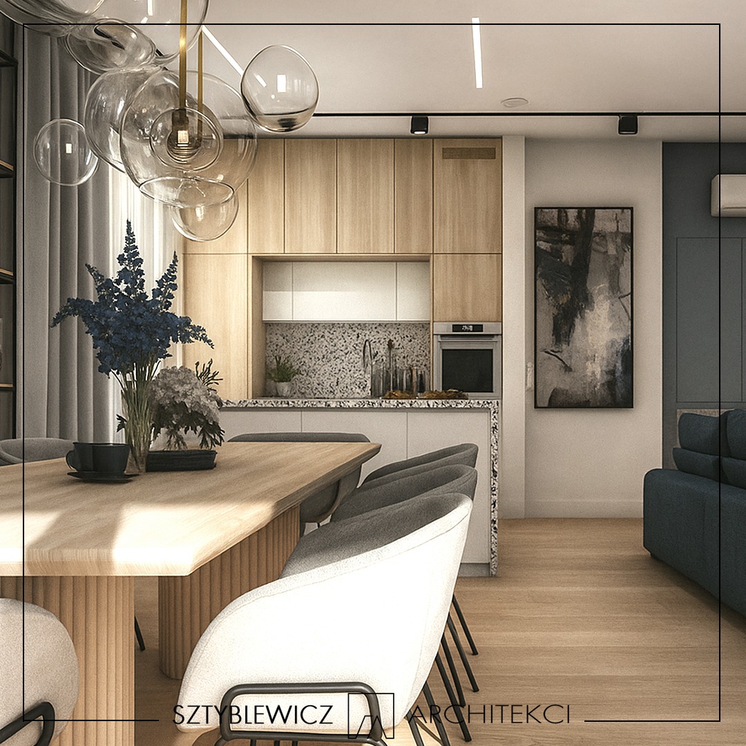 Nowoczesna aranżacja wnętrza: drewniana kuchnia z wyspą, stół z krzesłami i dekoracyjna lampa. Minimalistyczny design z akcentami kolorystycznymi.