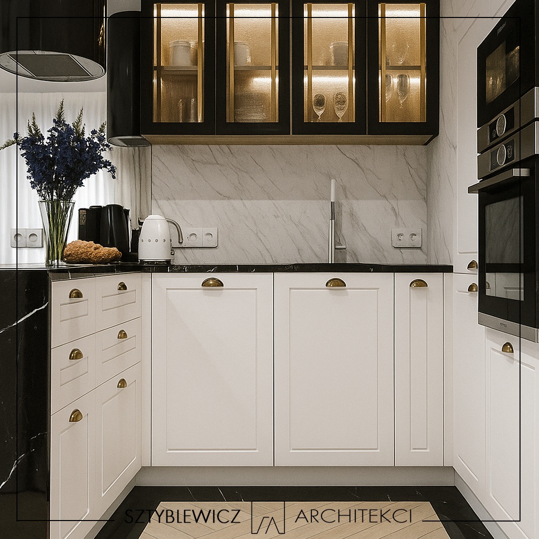 Elegancka kuchnia w bieli i czerni: marmurowe ściany, złote uchwyty, oświetlone szafki. Nowoczesny design z kwiatami w wazonie i czajnikiem.