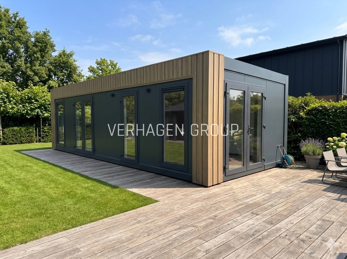 Nowoczesny, szary dom modułowy z drewnianymi akcentami, otoczony zielonym trawnikiem i drewnianym tarasem. Widoczne duże okna i drzwi przesuwne.