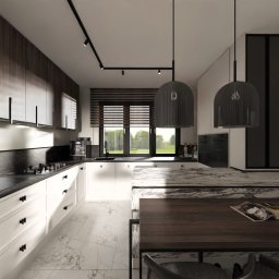 Hus architektura wnętrz - Nowoczesna kuchnia z białymi szafkami i marmurową podłogą. Centralnie wyspa z blatem z ciemnego drewna i lampami wiszącymi. Widok na ogród przez okno.