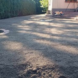 Daw Garden - Przygotowany teren pod trawnik z rolki, widoczne wyrównane podłoże, obrzeże rabaty i budynek w tle. W tle żywopłot.