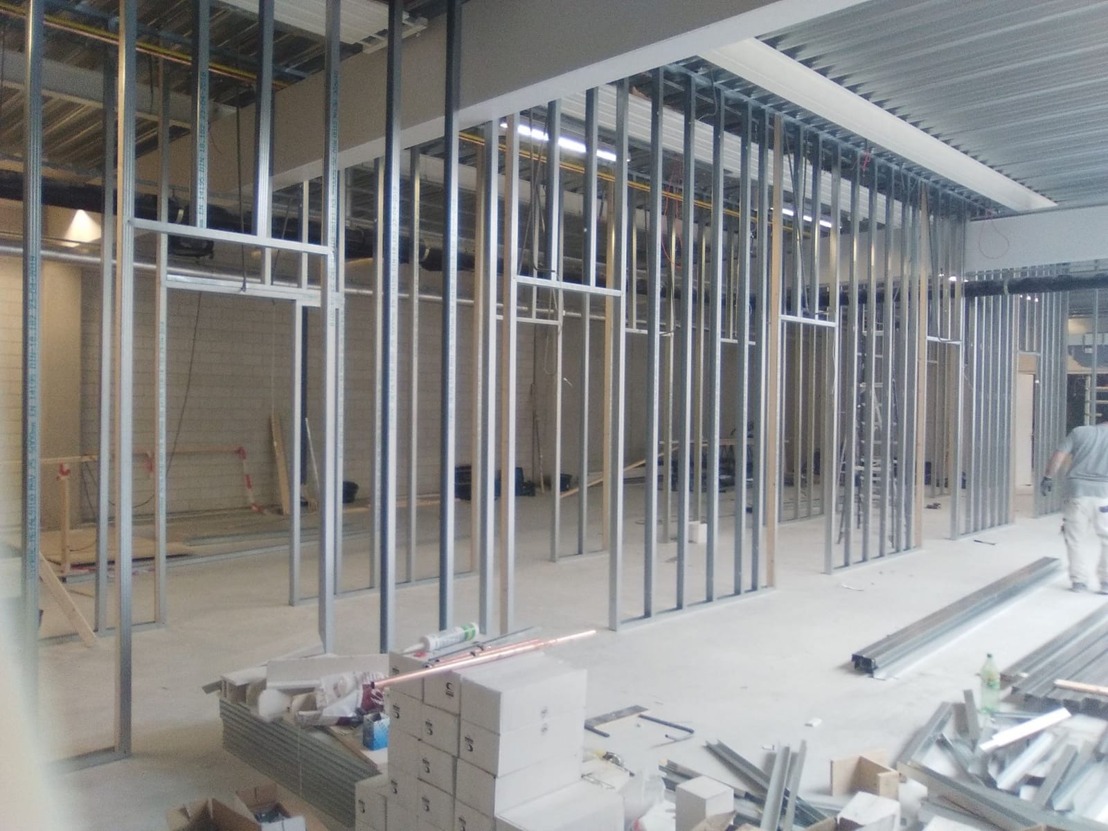 Konstrukcja ścian działowych z profili stalowych w Lipnie. Widoczne profile pionowe i poziome, przygotowane do montażu płyt. Prace wykończeniowe wewnątrz budynku.