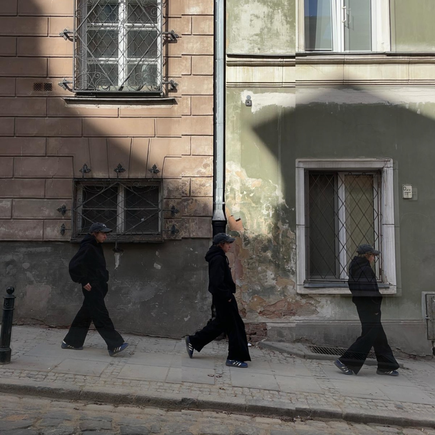Osoba w czarnym stroju spaceruje ulicą, efekt rozmycia ruchu i nałożenia klatek tworzy wrażenie multiplikacji. Stare budynki w tle, światło słoneczne.
