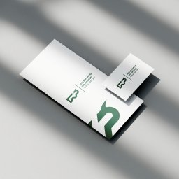 Jedenastka Studio - Elegancki zestaw wizytówek i papieru firmowego z zielonym logo Podlaskiego Urzędu Wojewódzkiego w Białymstoku, ułożony pod kątem na jasnoszarym tle.