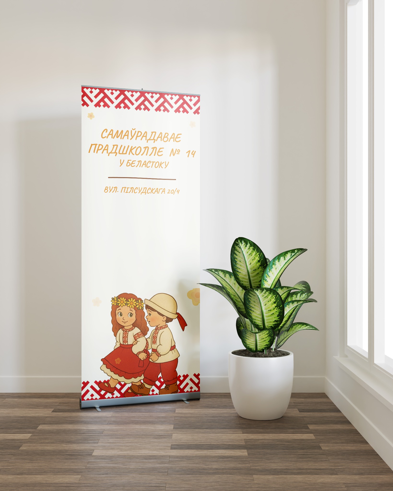 Roll-up z ilustracją dzieci w strojach ludowych i napisem w języku białoruskim, stojący w jasnym pomieszczeniu obok rośliny doniczkowej.