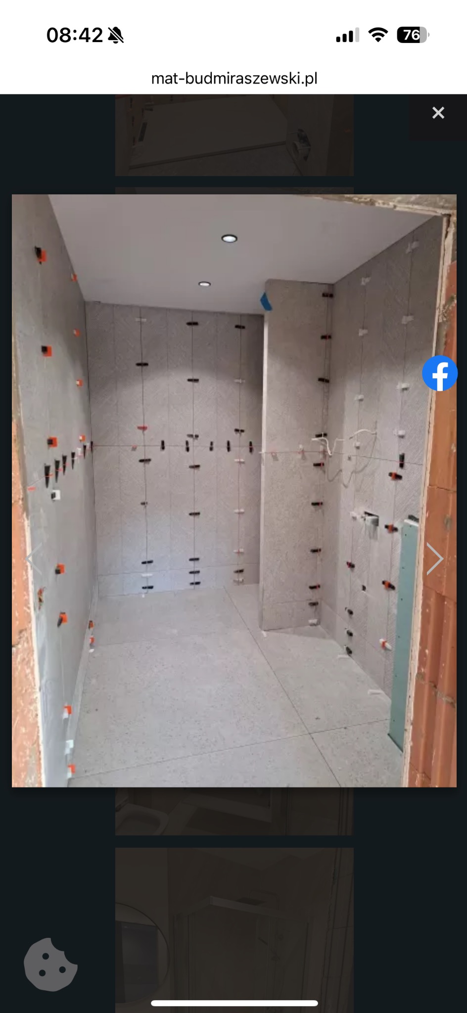 Łazienka w trakcie układania płytek. Widoczne krzyżyki dystansowe i sznurki poziomujące. Jasne płytki na ścianach i podłodze, sufit z oświetleniem punktowym.