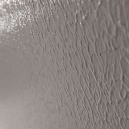 ORDEX SPÓŁKA Z OGRANICZONĄ ODPOWIEDZIALNOŚCIĄ - Świeżo nałożona, gładka szpachla na ścianie, z widoczną fakturą i połyskiem, uchwycona pod kątem, ukazująca detale wykończenia.