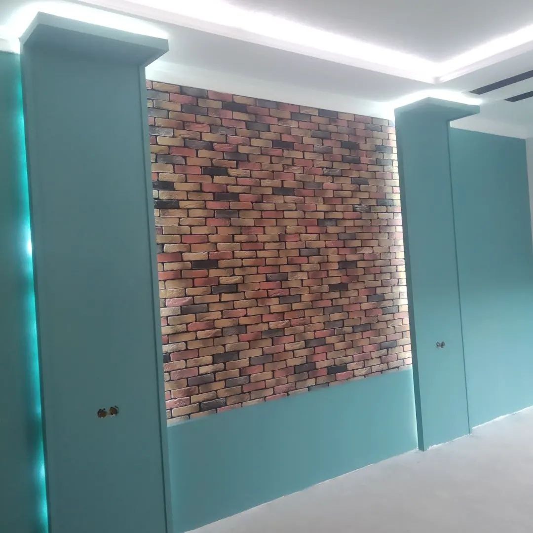 Ściana z cegły dekoracyjnej w turkusowym wnętrzu z oświetleniem LED. Wykończenie ściany imitujące mur, z kolumnami w kolorze ścian. Nowoczesny design.