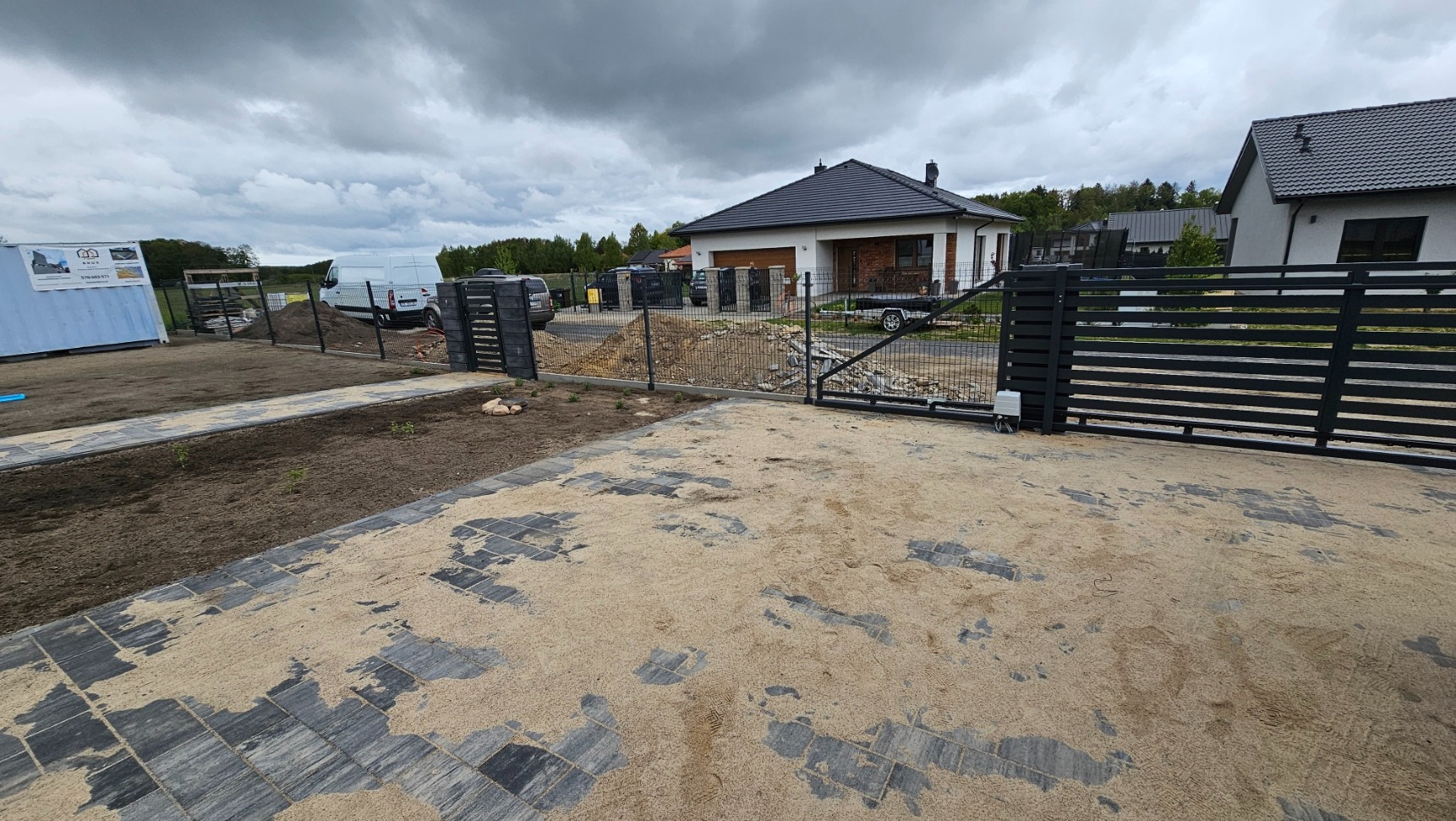 Nowoczesne ogrodzenie panelowe 3D z podmurówką i murowanymi słupkami JONIEC, brama i furtka ze sztachetowym wypełnieniem, automatyka, na tle domu jednorodzinnego.