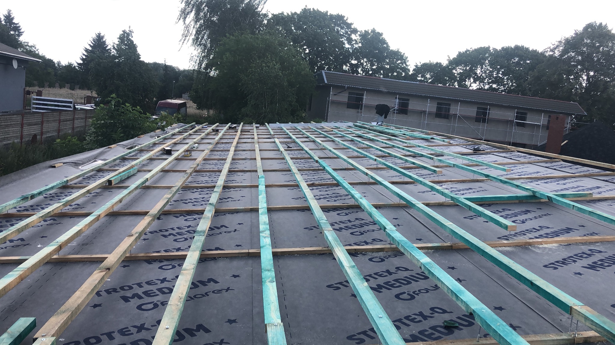 Konstrukcja dachu z łatami i membraną w Mielęcinie, przygotowana pod pokrycie. Widoczne drewniane elementy i czarna folia. Prace dekarskie w toku.