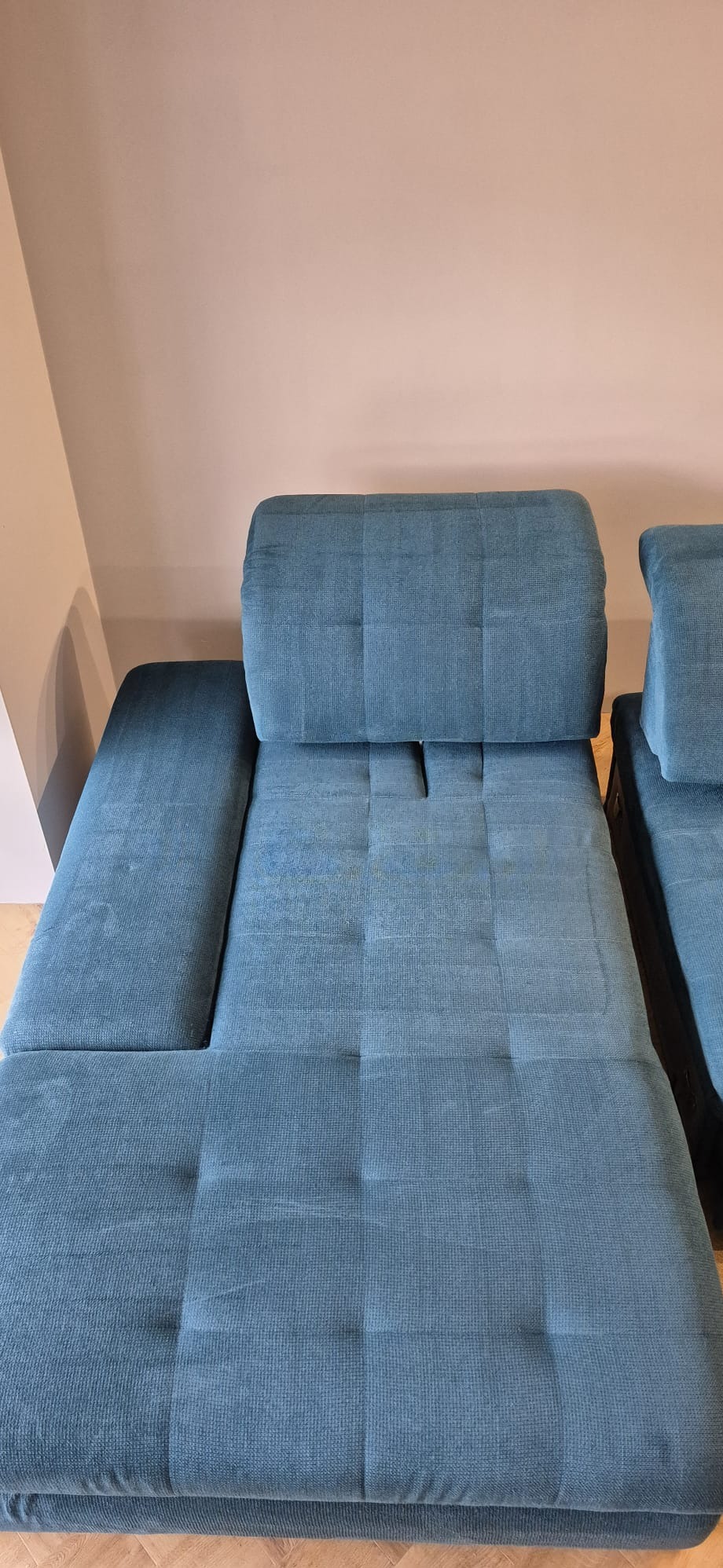 Turkusowa kanapa modułowa z widocznymi śladami po czyszczeniu tapicerki, ukazująca różnicę w odcieniu i strukturze materiału po zabiegu.