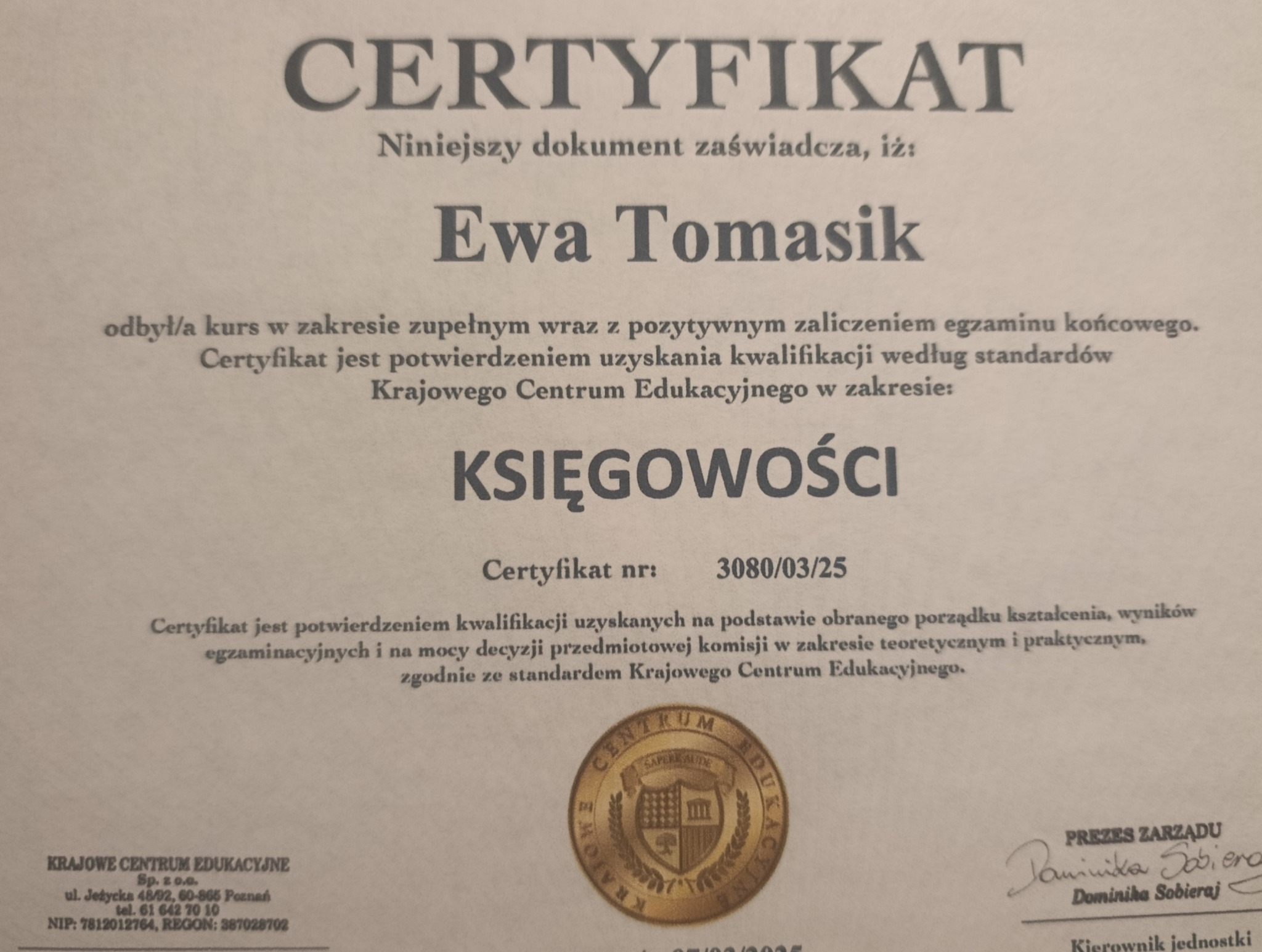 Certyfikat Ewy Tomasik z Krajowego Centrum Edukacyjnego w zakresie księgowości, numer 3080/03/25, z pieczęcią i podpisem Prezesa Zarządu Dominiki Sobieraj.