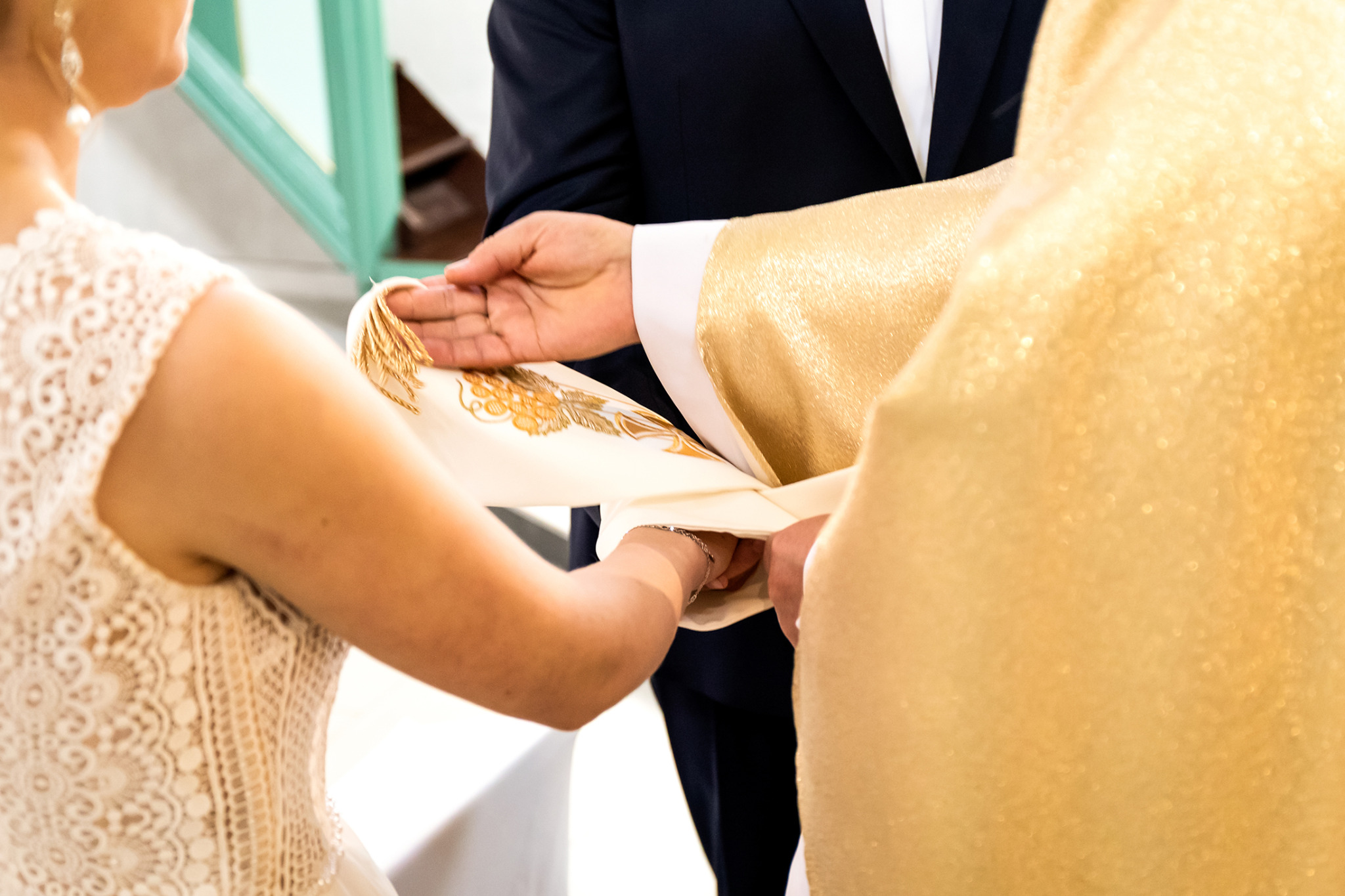 Ceremonia zaślubin w Sułkowicach: ksiądz łączy dłonie pary młodym stułą. Panna młoda w koronkowej sukni, pan młody w garniturze. Uroczysty moment.