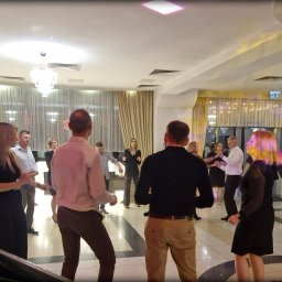 NEXA ENERGY Leszek Korycki - Parkiet taneczny wypełniony gośćmi podczas imprezy w sali balowej z kolumną dekoracyjną i nagłośnieniem. Widok zza konsoli DJ-a.