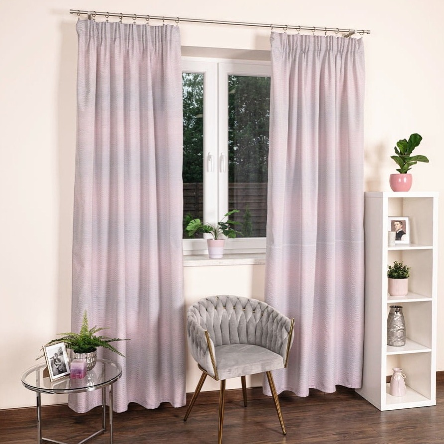 Delikatne, różowo-szare zasłony z subtelnym wzorem, wiszące w oknie. Obok krzesło w stylu glamour i stolik z rośliną, tworzące przytulną aranżację wnętrza.