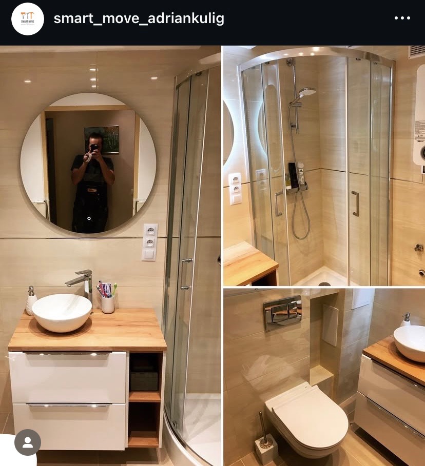 Jasna łazienka po remoncie: kabina prysznicowa, umywalka nablatowa na szafce z drewnianym blatem, okrągłe lustro z odbiciem osoby robiącej zdjęcie.