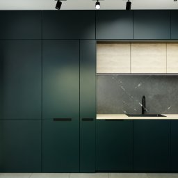 P2Studio Mateusz Grzesik - Nowoczesna kuchnia z ciemnozielonymi szafkami, drewnianymi blatami i czarną armaturą. Minimalistyczny design, oświetlenie punktowe.