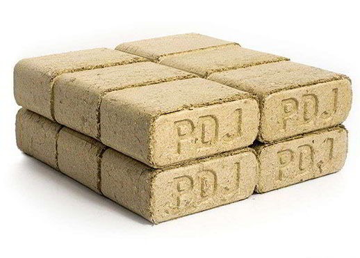 Ułożone w stosy sześć kostek brykietu drzewnego z widocznym wytłoczonym napisem 'PDJ' na każdej kostce, na białym tle.