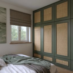 Totemi Marta Kowalska - Sypialnia w beżach i zieleni: łóżko z dekoracyjną narzutą, obraz nad wezgłowiem, okno z roletą rzymską i duża szafa z rattanowymi frontami w ciemnozielonej ramie.