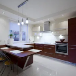 Nowoczesna kuchnia z brązowymi frontami szafek i białymi blatami, oświetlona wiszącymi lampami i punktowymi halogenami, z wyspą kuchenną pełniącą funkcję stołu jadalnego i dekoracyjnym obrazem kawy...