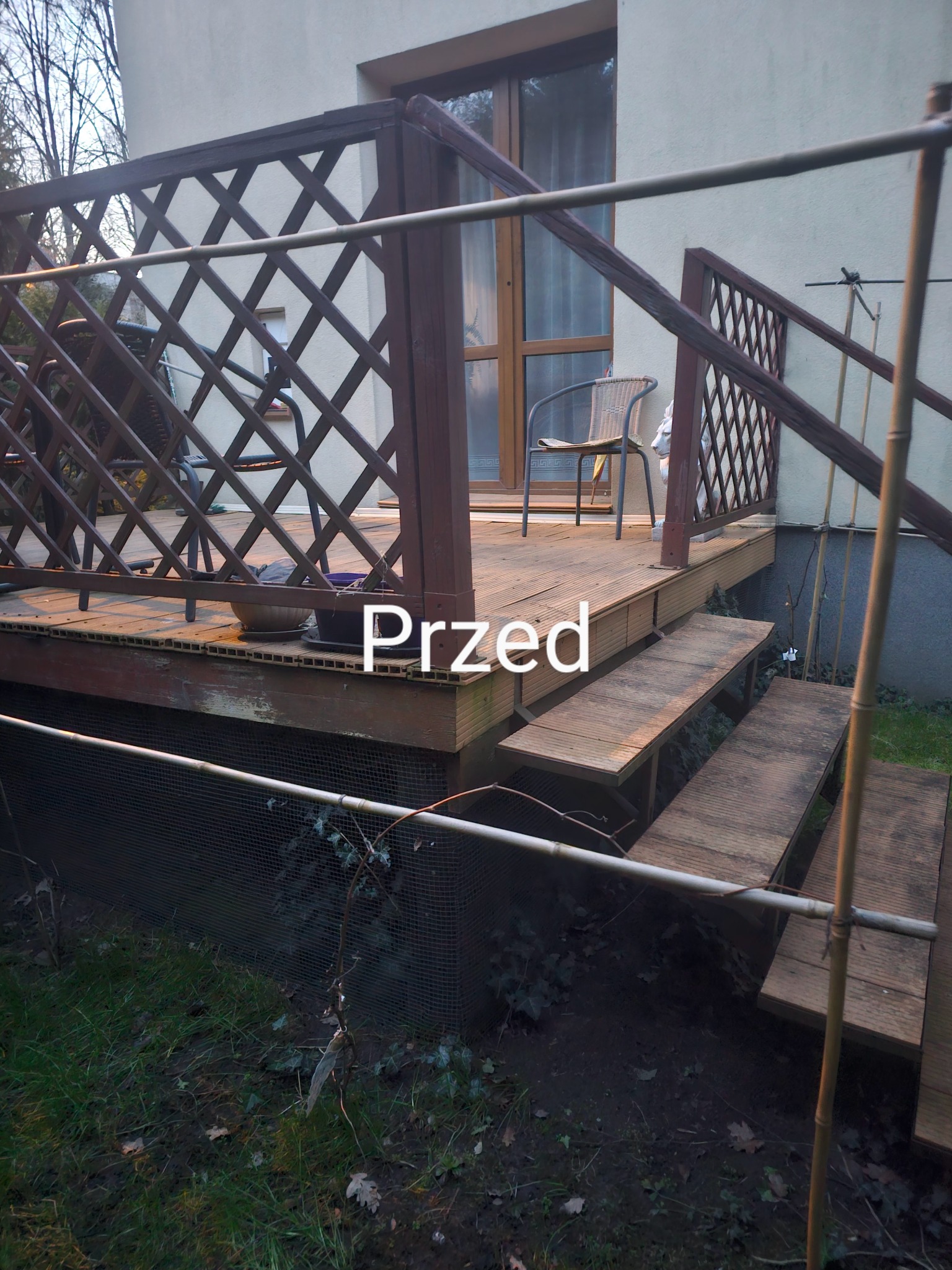 Drewniany taras z kratownicą i schodami przed renowacją. Widoczne ślady użytkowania i zabrudzenia. Ujęcie z niskiej perspektywy, z napisem 'Przed' na środku kadru.
