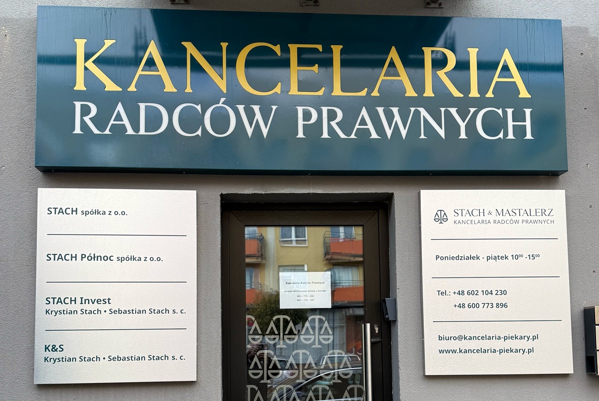 Wejście do Kancelarii Radców Prawnych Stach & Mastalerz z tablicą informacyjną o godzinach otwarcia i danymi kontaktowymi. Widoczne szyldy z nazwami spółek.