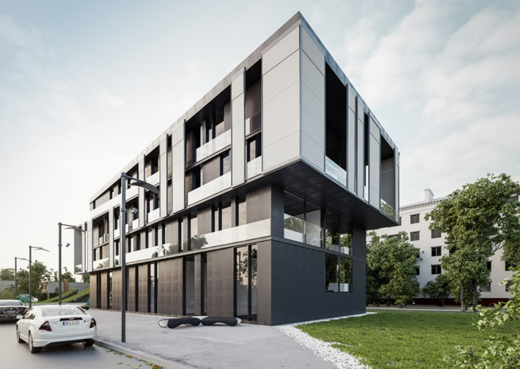 Nowoczesny budynek wielorodzinny z elewacją w odcieniach szarości i bieli, z widocznymi lamelami i dużymi przeszkleniami, otoczony zielenią i elementami małej architektury.