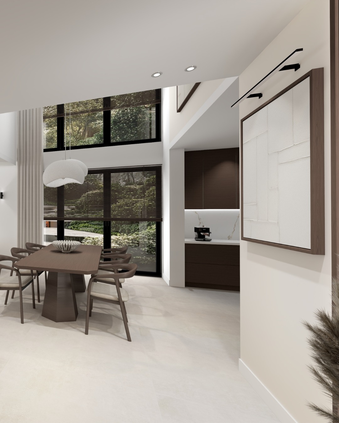 Jasne wnętrze jadalni z dużym oknem i minimalistyczną kuchnią w tle. Stół z krzesłami, nowoczesna lampa i abstrakcyjny obraz na ścianie tworzą spójną całość.