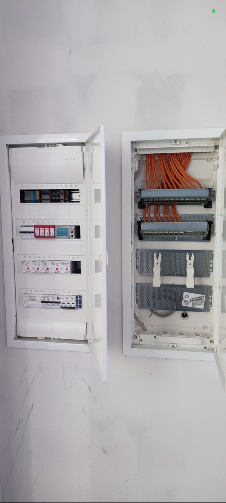 Otwarta skrzynka elektryczna z okablowaniem i bezpiecznikami, zamontowana na ścianie w Gorzowie Wielkopolskim. Widoczne pomarańczowe kable i elementy instalacji.