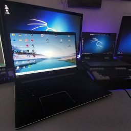 HUBICHEM Hubert Wodnicki - Stanowisko pracy IT w Pyrzycach: kilka monitorów i laptopów z uruchomionym kodem i systemem operacyjnym Kali Linux. Podświetlana klawiatura mechaniczna.