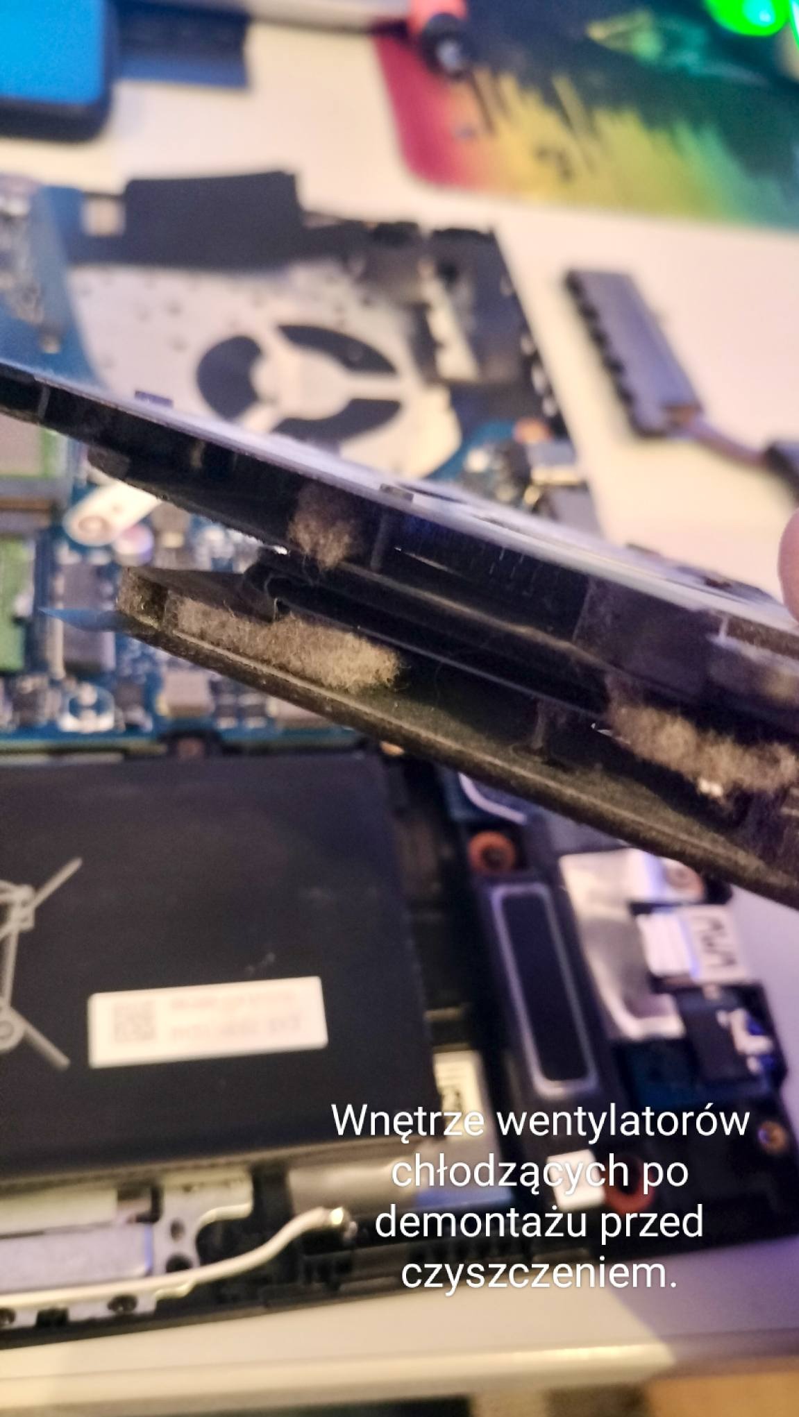 Wnętrze wentylatorów chłodzących laptopa, widoczne po demontażu, przed czyszczeniem. Nagromadzony kurz i brud wewnątrz obudowy wentylatora.