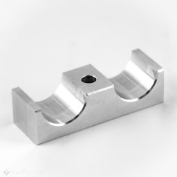 FrezTech CNC Piotr Skiba - Precyzyjnie obrobiony element metalowy CNC z otworem, widoczne ślady frezowania, na jasnym tle. Detal z bliska, ukazujący dokładność wykonania.