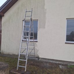 Kolor wash - Fragment elewacji domu z drabiną, ukazujący obszar po malowaniu i obszar wymagający odświeżenia. Widoczne różnice w kolorze i czystości powierzchni.