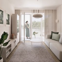 MADE ARCHITEKTURA - Jasne wnętrze salonu z wyjściem na balkon. Kobieta w sukience stoi na balkonie. Minimalistyczny design, drewniana podłoga, dywan, sofa i szafka RTV. Roślina w doniczce.