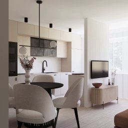MADE ARCHITEKTURA - Jasne wnętrze: kuchnia z jadalnią w neutralnych barwach. Okrągły stół z krzesłami, minimalistyczna zabudowa kuchenna, telewizor na ścianie z lamelami. Nowoczesny design.