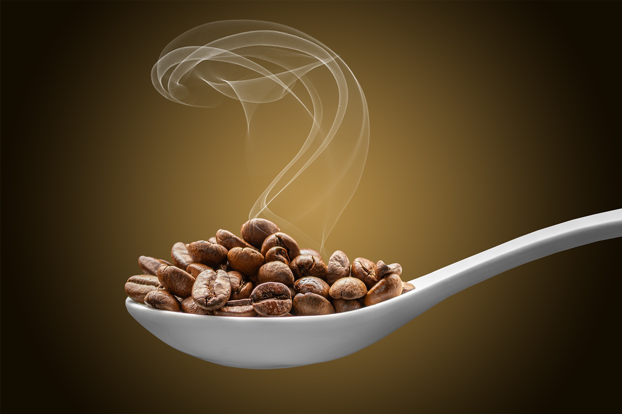 Błyszczące ziarna kawy w białej łyżce, unoszący się dym, na ciemnym, gradientowym tle. Precyzyjne oświetlenie podkreśla detale i teksturę ziaren.