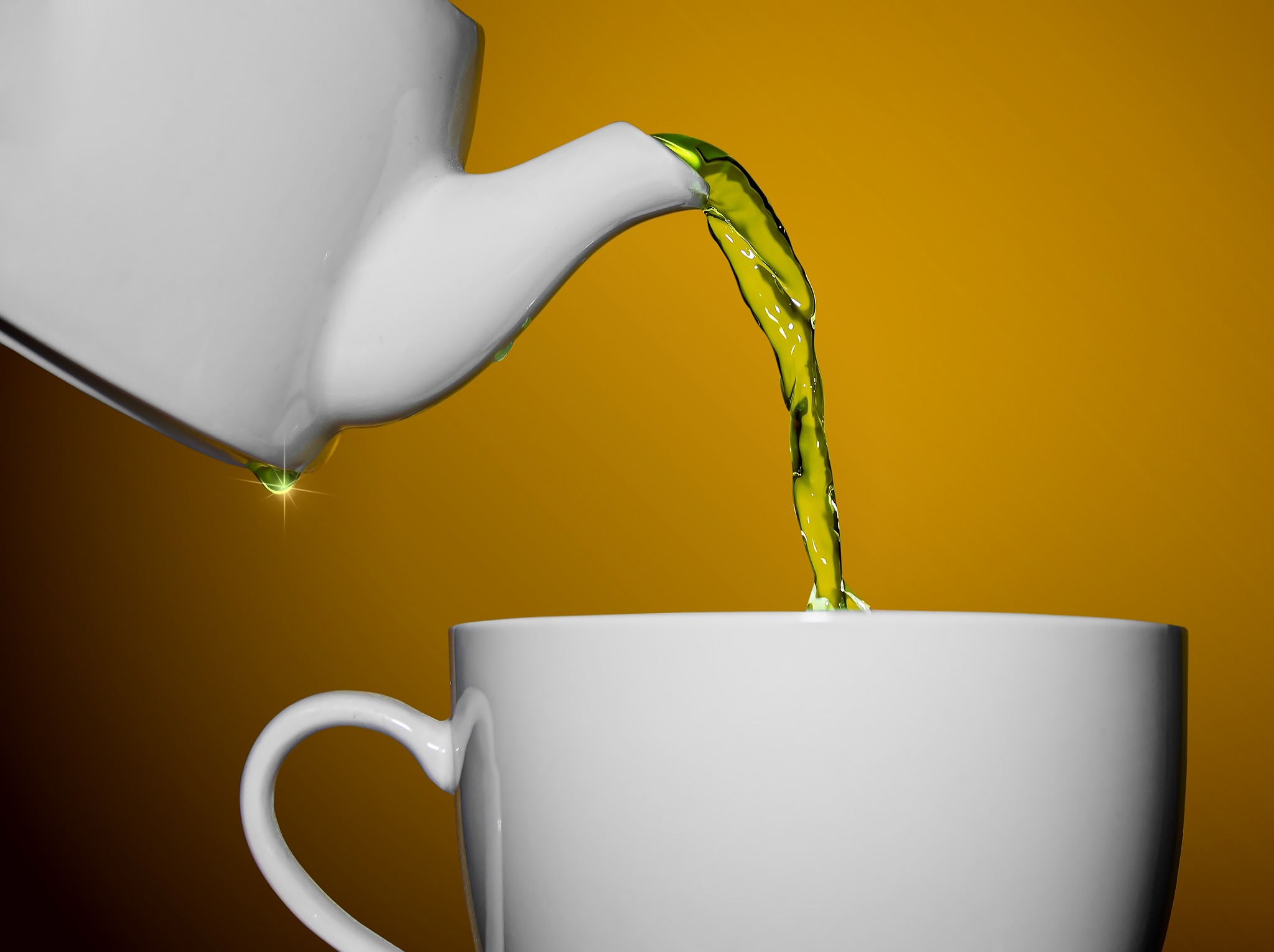 Biały dzbanek nalewa zielony płyn do białego kubka na tle w odcieniach żółci. Kropla płynu z efektem blasku. Minimalistyczne ujęcie, ostre detale.