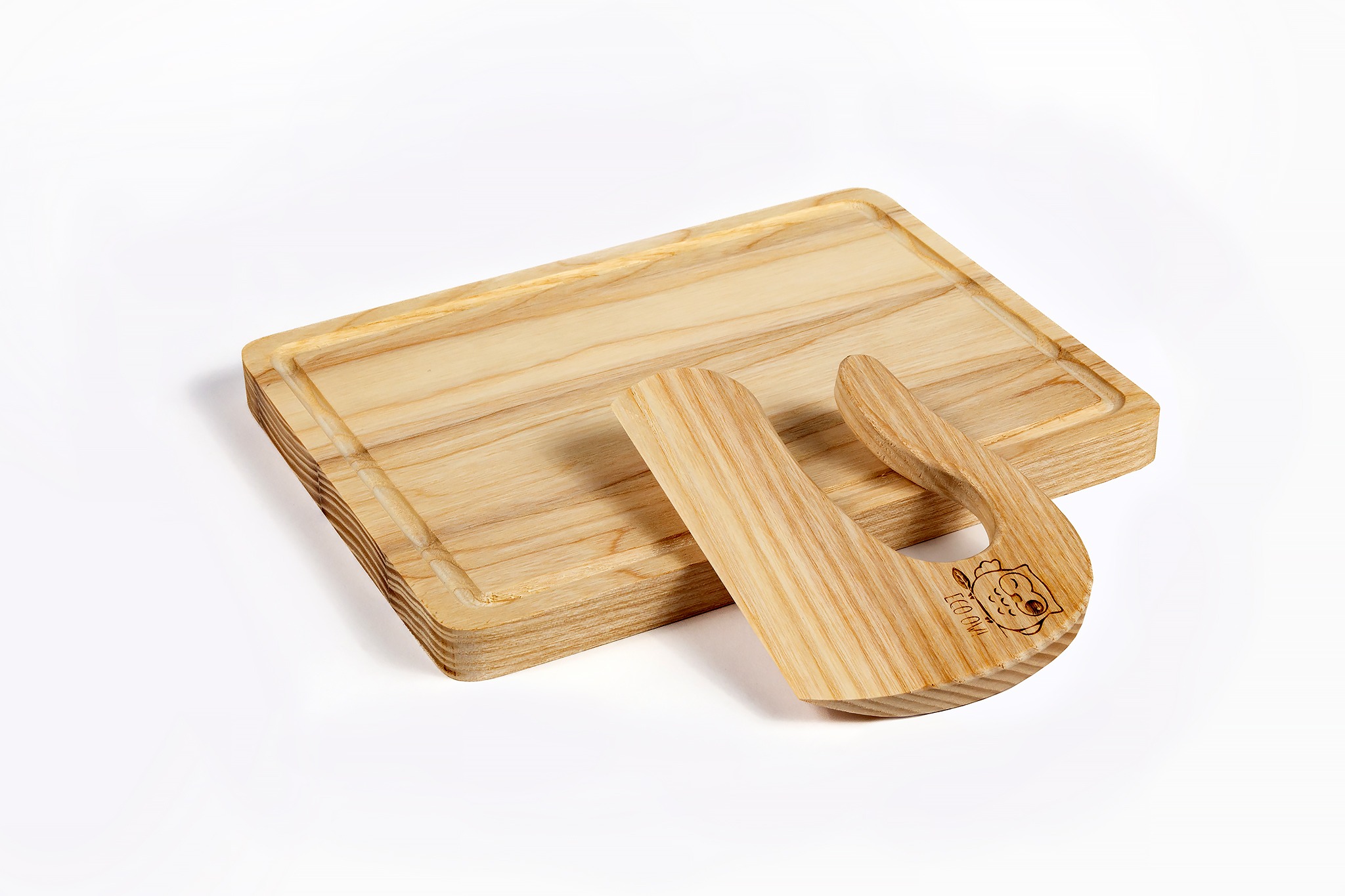 Drewniana deska do krojenia z rowkiem i nóż kołyskowy z wygrawerowanym motywem sowy na białym tle. Naturalne drewno, jasne oświetlenie, widoczne słoje.