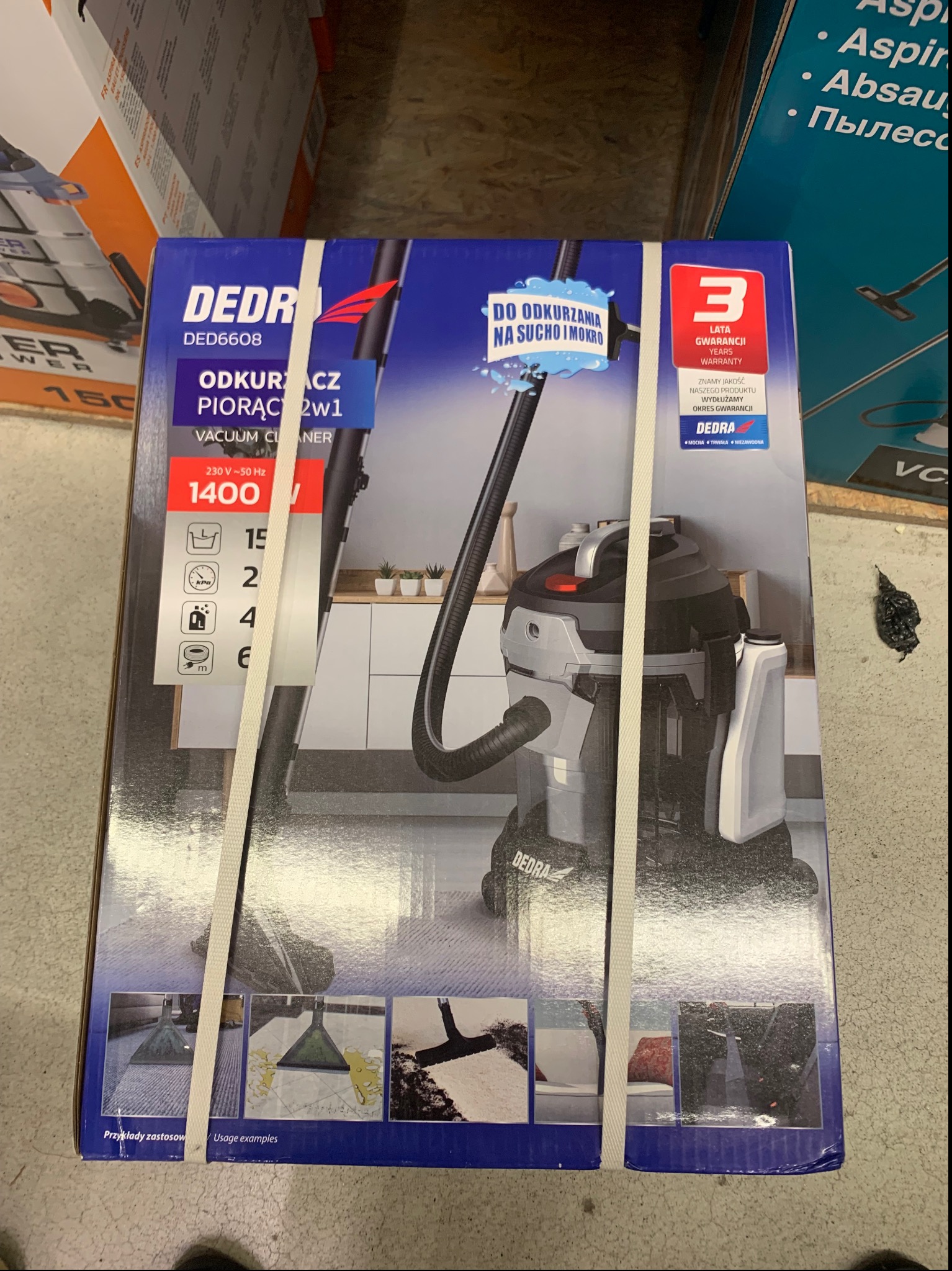 Pudełko odkurzacza piorącego Dedra 2w1, z opisem 'do odkurzania na sucho i mokro', prezentowane w Gorzowie Wielkopolskim. Widoczne przykłady zastosowania.