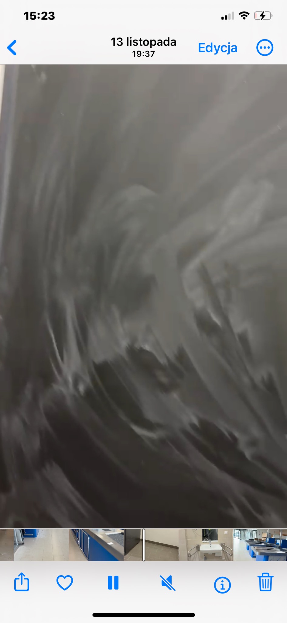 Świeżo umyta, mokra tablica w szkole lub biurze, z widocznymi smugami wody. W dolnej części ekranu widoczne miniatury innych zdjęć z galerii.