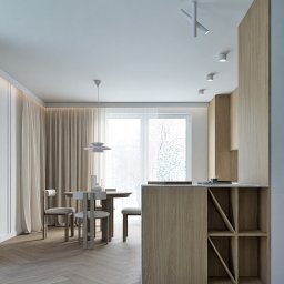 Studio projektowania wnętrz - Kwadrat na miarę - Jasne wnętrze: parkiet w jodełkę, stół z krzesłami, minimalistyczna lampa wisząca i zabudowa kuchenna z drewnianymi frontami. Nowoczesny design.