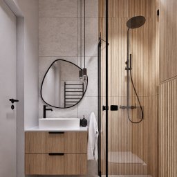 Studio projektowania wnętrz - Kwadrat na miarę - Nowoczesna łazienka z drewnianymi akcentami: kabina prysznicowa z deszczownicą, umywalka nablatowa z szafką, asymetryczne lustro i minimalistyczne oświetlenie.