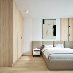 Studio projektowania wnętrz - Kwadrat na miarę - Nowoczesna sypialnia z drewnianą zabudową, minimalistycznym oświetleniem i abstrakcyjnym obrazem nad łóżkiem. Jasne kolory i proste linie tworzą spokojną atmosferę.