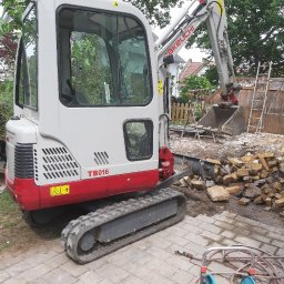 CIRO BAU SPÓŁKA Z OGRANICZONĄ ODPOWIEDZIALNOŚCIĄ - Mini koparka Takeuchi TB016 na posesji z gruzem i ziemią, widoczne ogrodzenie i drabina. Prace ziemne w ogrodzie, sprzęt budowlany w akcji.