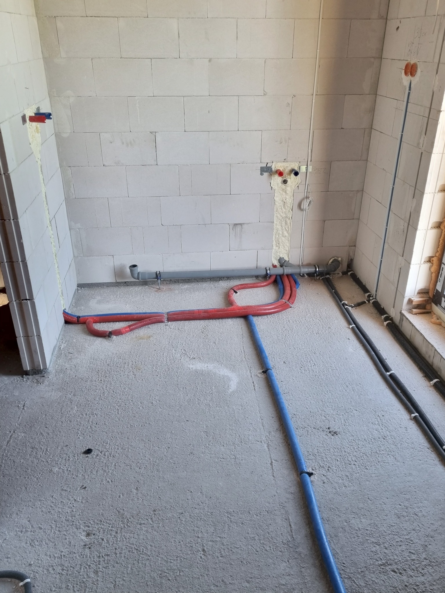 Instalacja wodna i kanalizacyjna w surowym stanie w Proszkowie. Rury grzewcze w izolacji, podejścia pod baterie i odpływy w ścianach z betonu komórkowego.