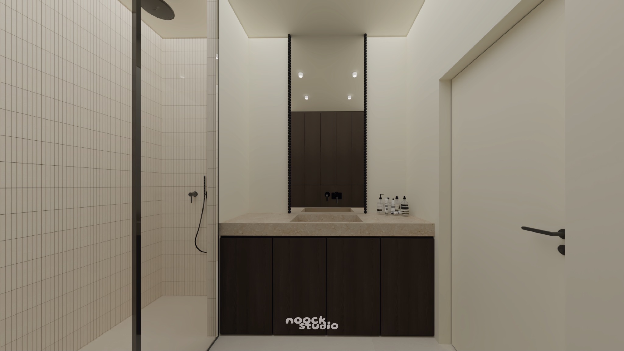 Minimalistyczna łazienka z kabiną prysznicową, umywalką z szafką i lustrem w ciemnej ramie. Beżowe płytki i stonowana kolorystyka tworzą spójną całość.