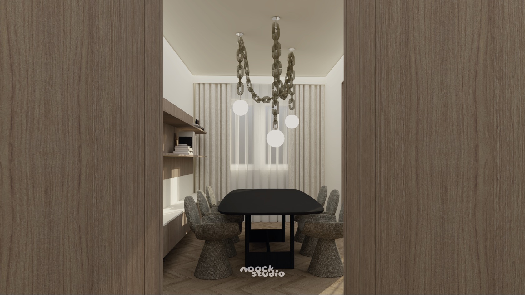 Wnętrze jadalni z czarnym stołem i szarymi krzesłami, oświetlone designerską lampą łańcuchową. Widok przez drewniane drzwi, z półką na książki w tle.