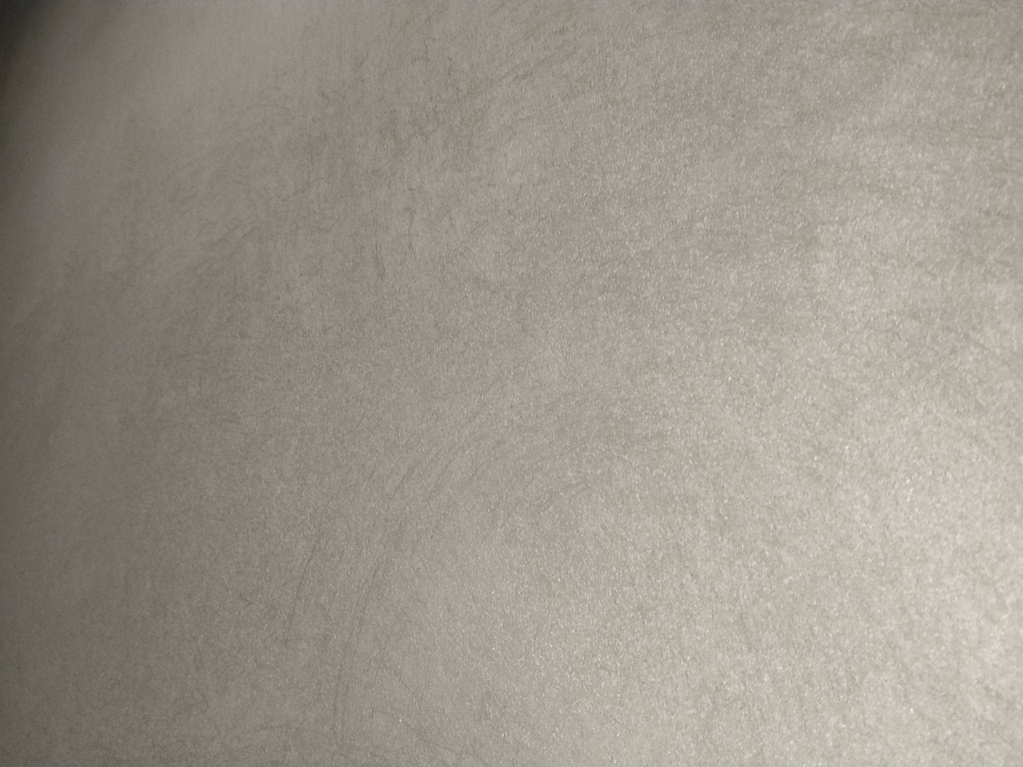 Gładka, beżowa ściana po tynkowaniu maszynowym z delikatną fakturą i subtelnymi smugami światła, ukazująca precyzję wykonania i estetyczny wygląd.